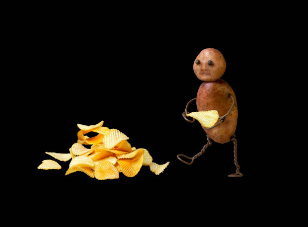 有趣的土豆人与头部和躯干烹饪和携带土豆瓦楞片在一个黑色孤立的背景图片下载