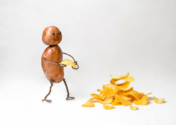 有趣的土豆人与头部和躯干烹饪和携带土豆瓦楞片在白色孤立的背景。图片下载