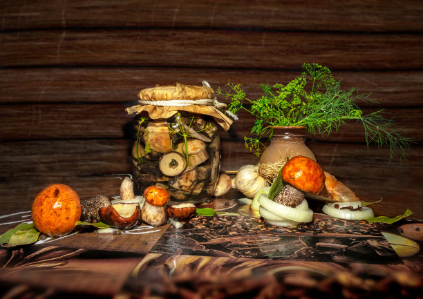 森林蘑菇，牛肝菌在一个玻璃罐里加香料。装罐和收割。深色木质背景上的腌蘑菇图片下载