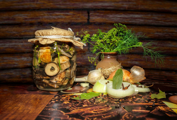 森林蘑菇，牛肝菌在一个玻璃罐里加香料。装罐和收割。深色木质背景上的腌蘑菇图片下载