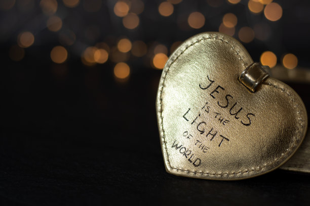 耶稣是世界的光，手写的文字诗句在闪亮的金色心脏与黑暗散景背景图片下载