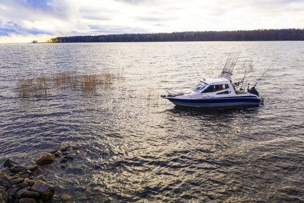 航拍渔夫在船上在海洋。与渔船俯瞰美丽的海景。鸟瞰钓鱼摩托艇与垂钓者。海洋海水的波浪反射。海洋里的汽艇。图片下载