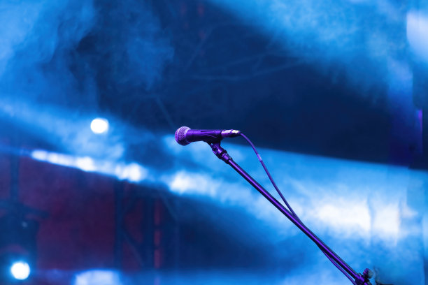 音乐会的麦克风准备在黑暗的舞台上表演，深蓝色的背景，一片空旷的黑暗场景。图片下载