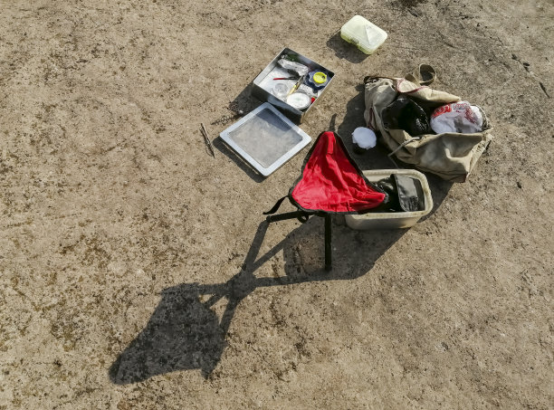 准备钓具和红椅子。水泥地板上的钓鱼用具。室外钓鱼设备已经布置完毕。图片下载