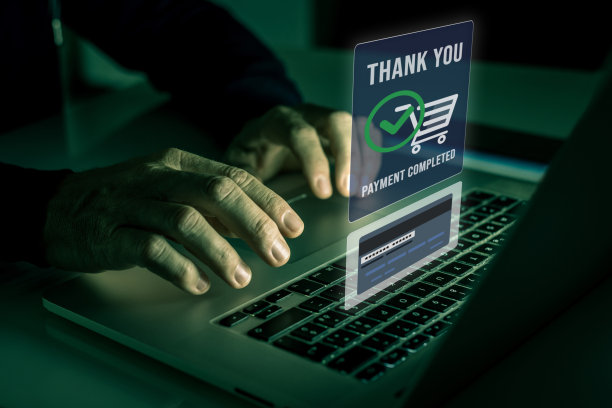 男人的手放在笔记本电脑键盘上，用信用卡在线购买和支付。安全付款完成图片下载