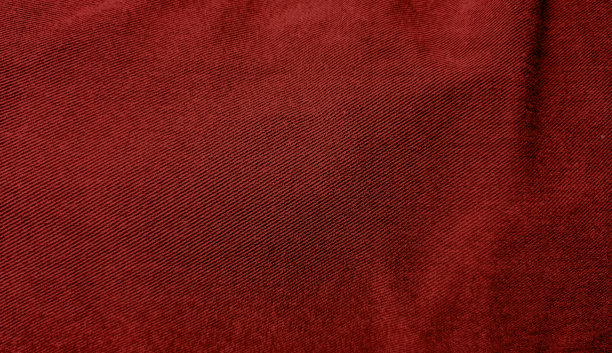 背景为红色牛仔裤牛仔面料纹理留白设计，近距离查看。红色牛仔布背景的粗糙布。高度细节的红色牛仔裤纹理。图片下载