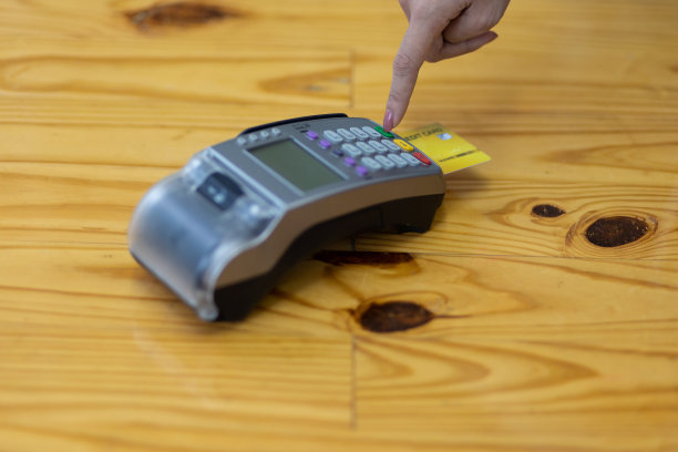 女性手持信用卡使用刷卡机支付。图片下载