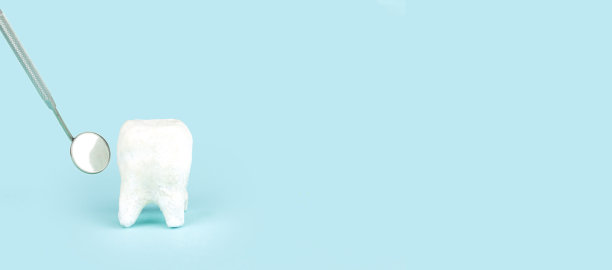 牙科牙齿模型与金属医疗牙科设备工具-牙齿牙医嘴镜，牙科护理在蓝色背景与复制空间，特写。图片下载