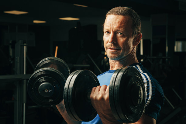 五十多岁的老人在健身房举重图片下载