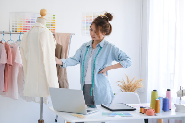 年轻的妇女和时装设计师正在创造新的布料系列。图片下载