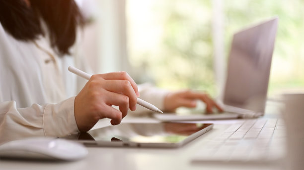 侧视图图像的亚洲女商人持有手写笔，使用数字平板电脑图片下载