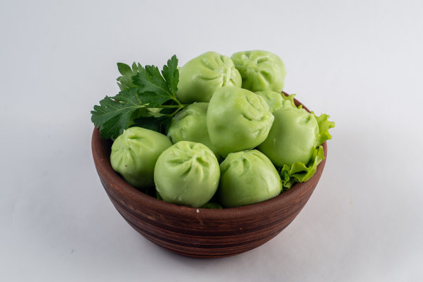 白底的盘子里盛着用香料调味的水饺。图片下载