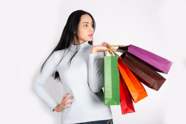 有吸引力的美丽的亚洲女人拿着购物袋模型孤立的白色背景。图片下载