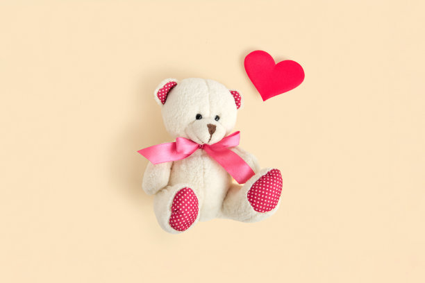情人节。爱的心。泰迪熊和红心在中性米色粉彩背景。复古浪漫风格。不寻常的创意贺卡。家庭、婚礼和友谊。俯视图图片下载