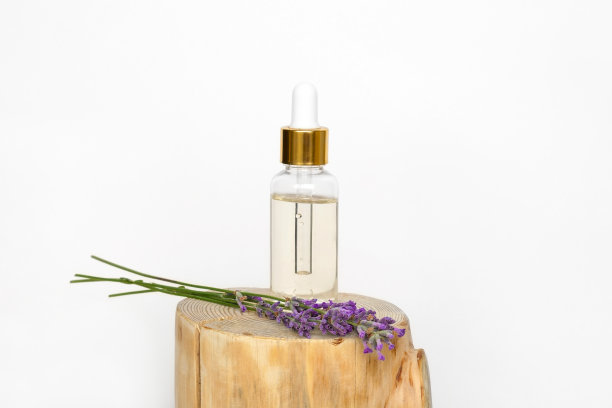 将薰衣草花放在木碗和一瓶薰衣草精油或纯净水中晾干。草本化妆品的天然有机成分。水疗按摩套装，薰衣草产品图片下载