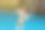 一位身穿黑色泳装的黑发成年女子微笑着站在瀑布边的水里图片下载