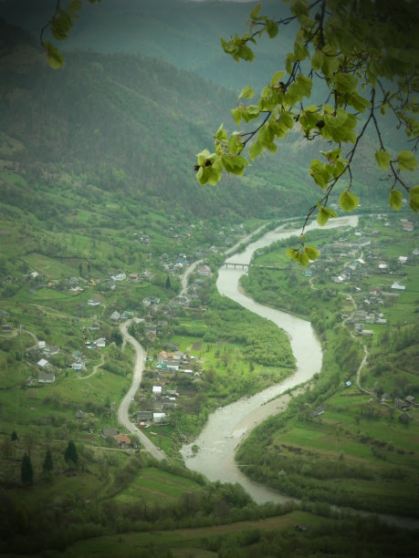 蜿蜒河流穿过小山村的山谷顶视图图片下载