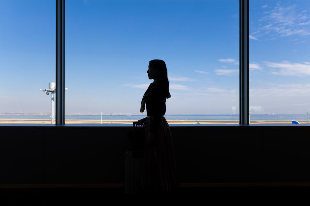 年轻女商人在机场的剪影图片下载