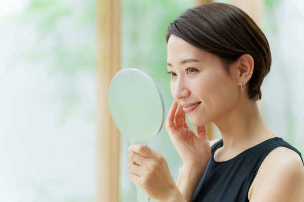 有吸引力的亚洲女人穿着黑色连衣裙看镜子图片下载