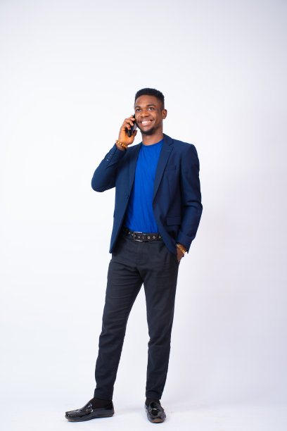 一名西装革履的非洲商人在一堵白墙前打电话图片下载