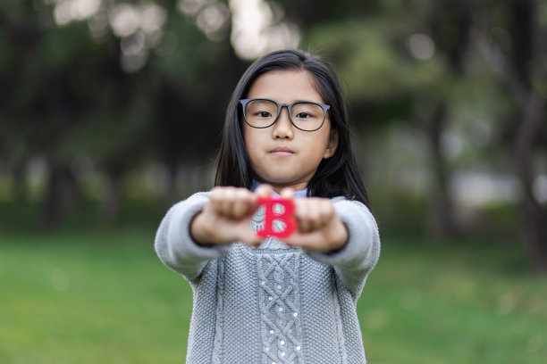 小女孩拿着字母“B”图片下载