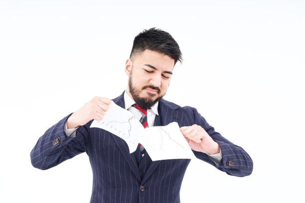 一个西装革履的男人在撕材料图片下载