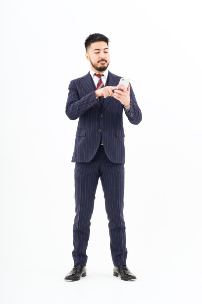 一个西装革履的男人在操作智能手机图片下载