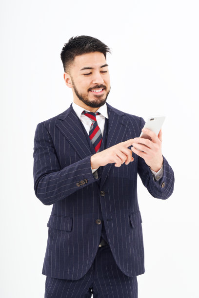 一个西装革履的男人在操作智能手机图片下载