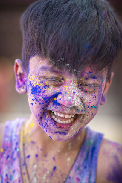 小男孩的肖像，笑着享受洒红节的色彩。图片下载
