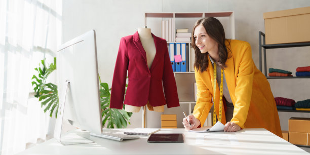 年轻漂亮的专业设计师在设计工作室室内工作。时装设计师概念图片下载