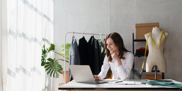 年轻漂亮的专业设计师在设计工作室室内工作。时装设计师概念图片下载