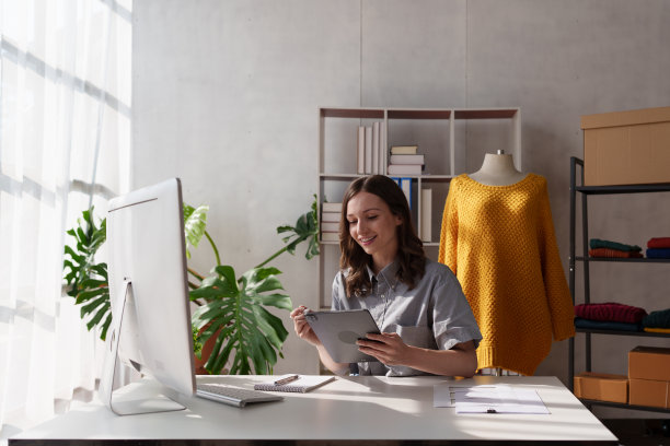 年轻漂亮的专业设计师在设计工作室室内工作。时装设计师概念图片下载