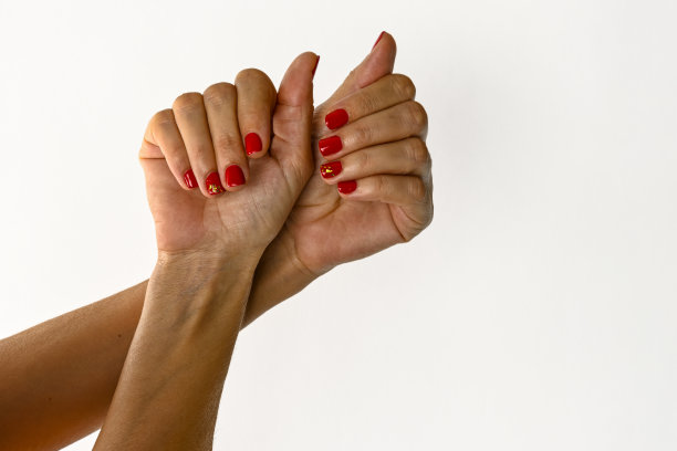 一名年轻女子的手显示涂了指甲油，白色背景。图片下载