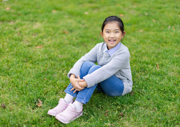 小女孩坐在草地上图片下载