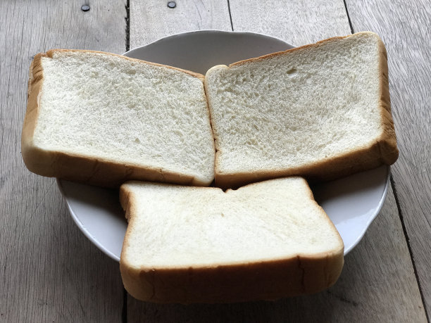 面包在木质背景上。乡村黑麦。新鲜的面包的乡村传统的木质纹理背景。面包店有硬皮面包。烘焙产品标签、设计等设计元素图片下载