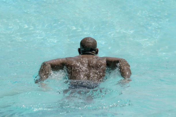 在游泳池里游泳的运动员，照片图片下载