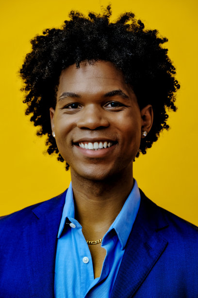 开朗的年轻成年男子与爆炸头的头发灿烂的微笑在工作室图片下载