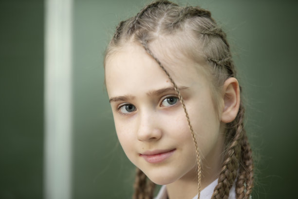 一个梳着辫子的女学生的特写肖像。图片下载
