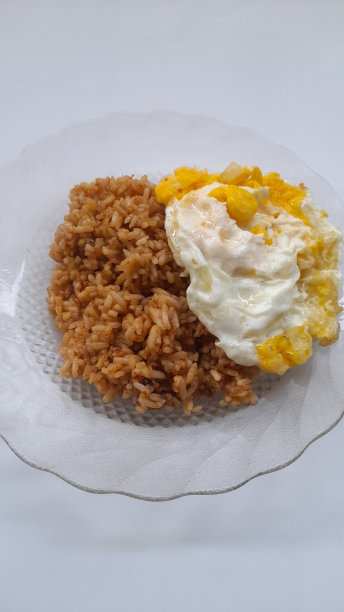 白色背景下的盘子上的炒饭和煎蛋。图片下载