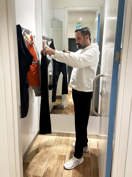 男子在服装店试衣间试衣服图片下载