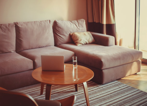 在舒适的房间里的灰色沙发上打开笔记本电脑图片下载