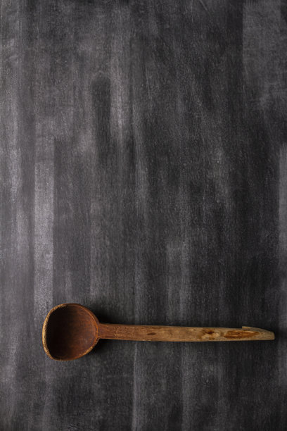 黑色背景的旧大木勺。图片下载