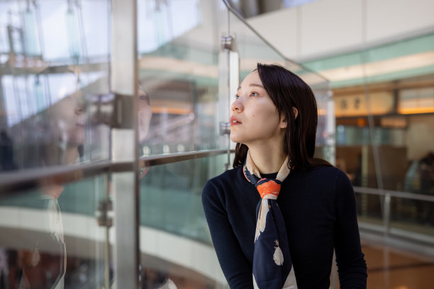 年轻的女商人在机场透过窗户看风景图片下载