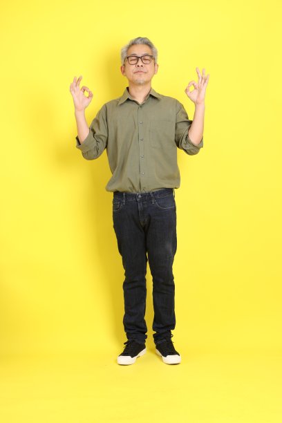 40多岁的亚洲成年男子，穿着休闲，站在黄色背景上。图片下载
