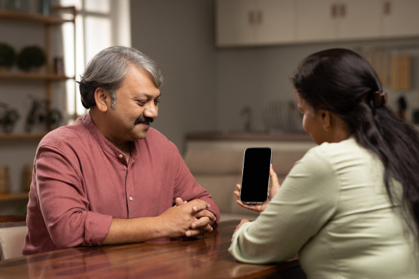 成熟男人向妻子展示智能手机。库存图片图片下载