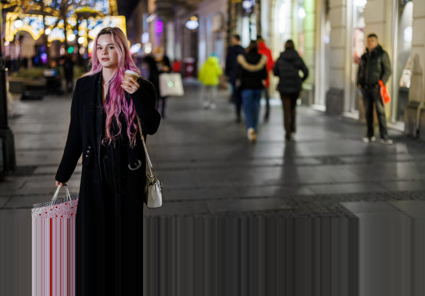 一个女人提着纸袋走在市区，享受着购物的乐趣。图片下载