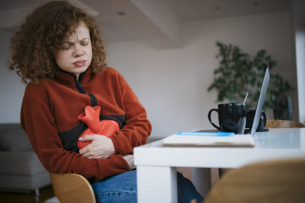 年轻女子在家工作时胃痛图片下载