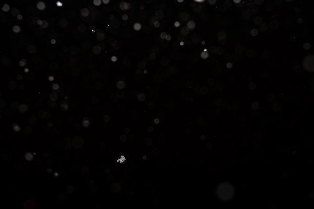 黑色背景上孤立的降雪。抽象的白色散景背景。图片下载