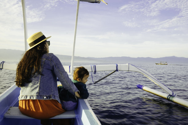 亚洲妇女带着她的孩子在划船度假图片下载