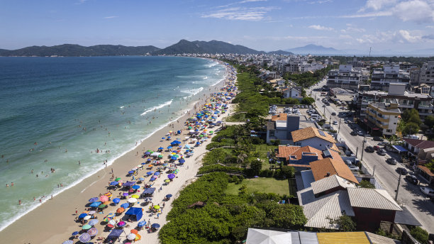 带着雨伞的绿水海滩图片下载